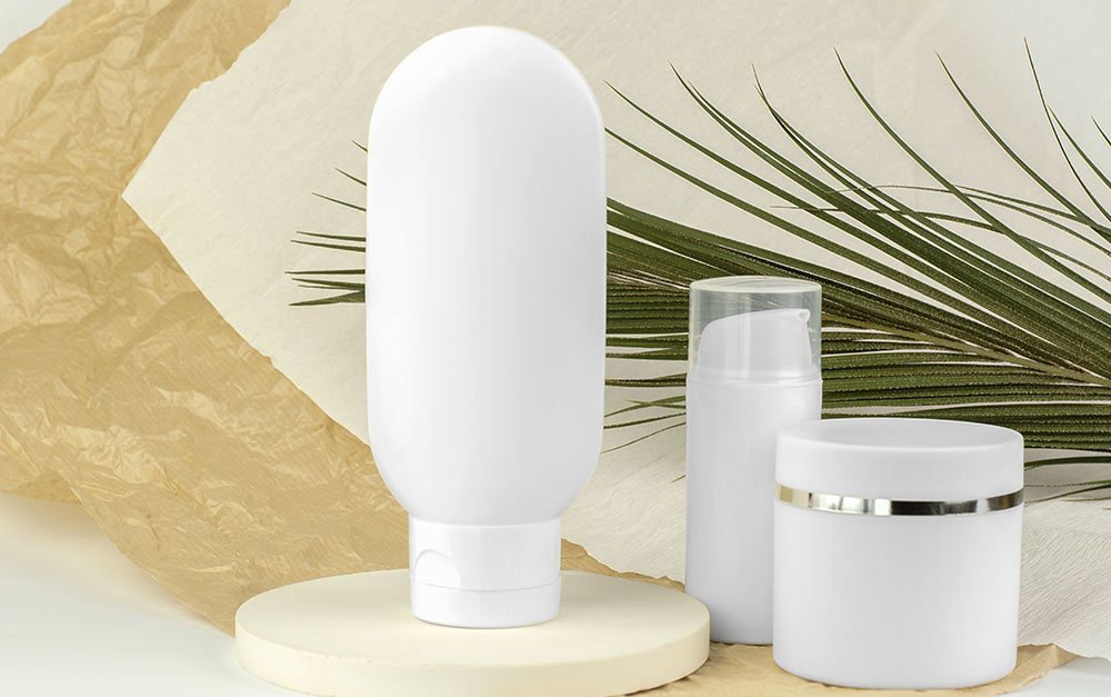 3 opções de embalagem plástica branca sendo utilizadas para comportar cosméticos